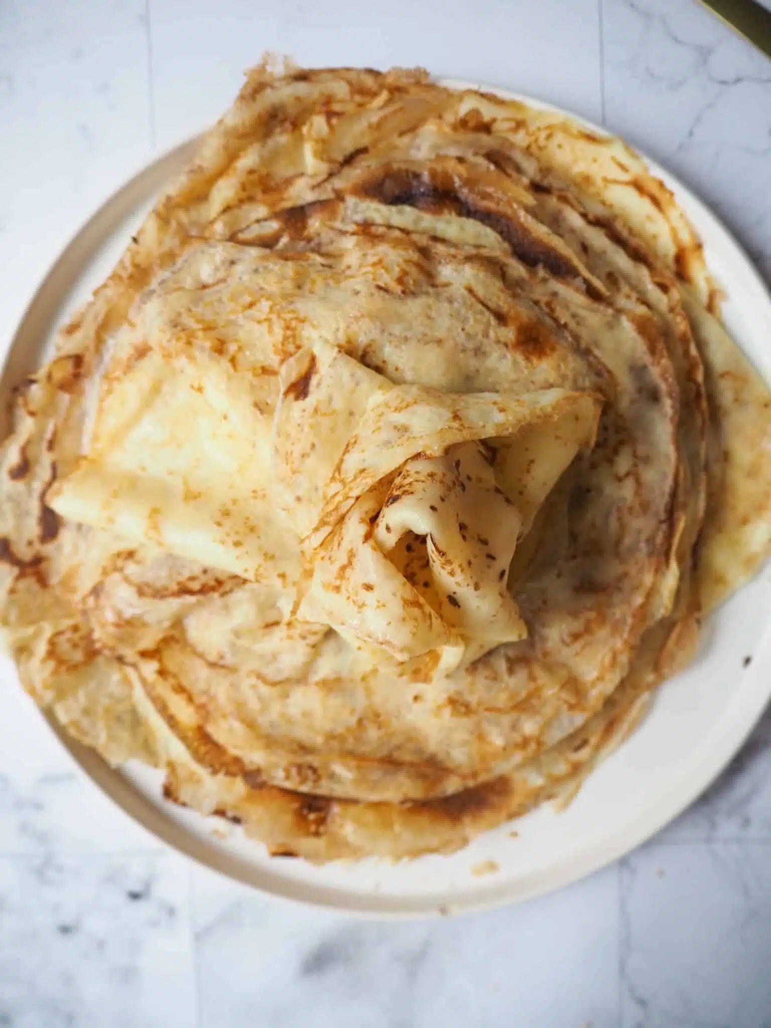 Crêpes légères empilées sur une assiette, idéales pour des recettes low fodmap