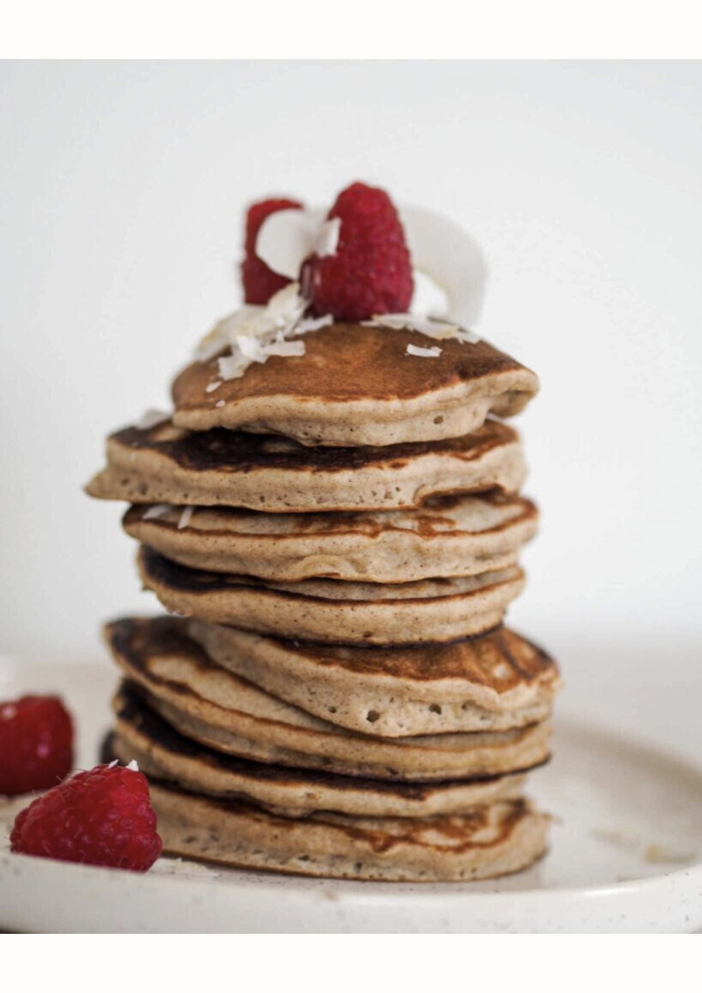 Tour de pancakes 3 ingrédients garnie de framboises et noix de coco, idéale pour un brunch léger