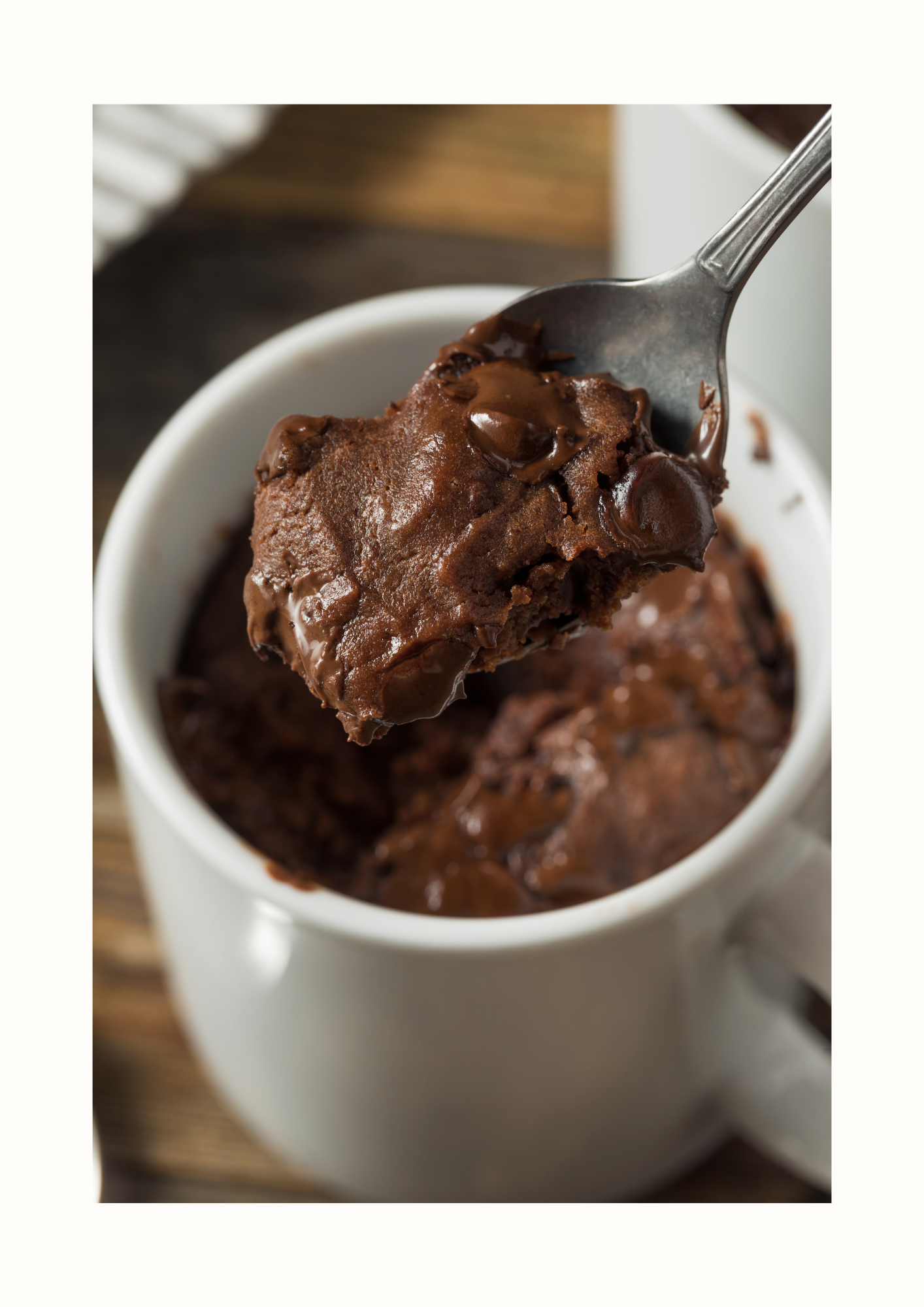 Mugcake chocolat express dans une tasse avec une cuillère plongeant dans le dessert moelleux