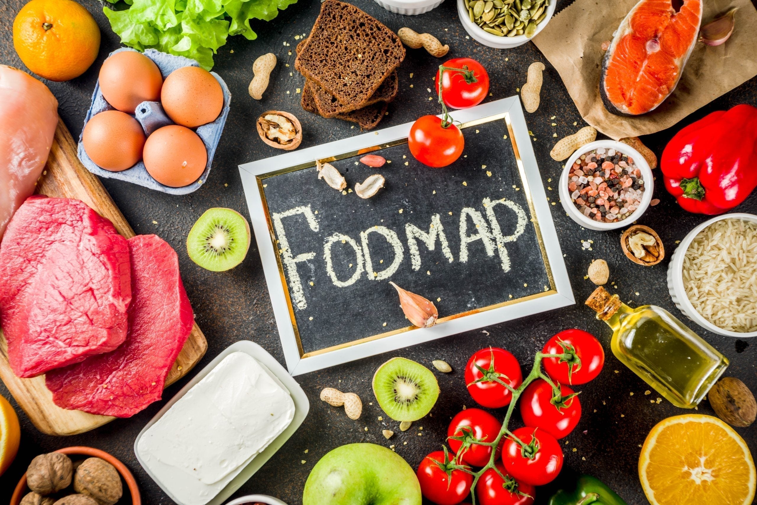 Divers aliments sains autour d'un tableau noir avec le mot FODMAP illustrant la méthode Low FODMAP