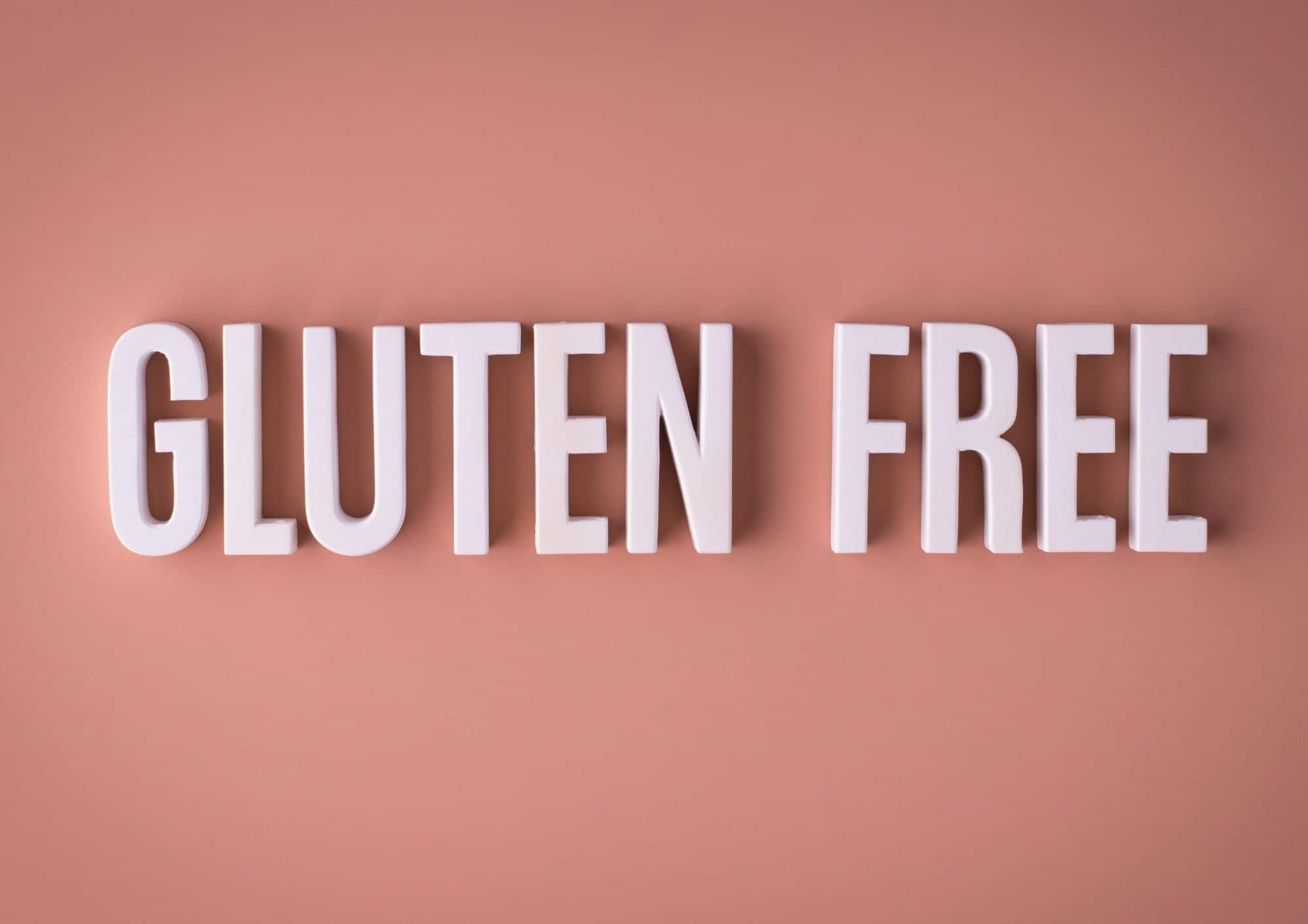 Texte gluten free en lettres blanches sur fond rose illustrant la prise en charge alimentation sans gluten