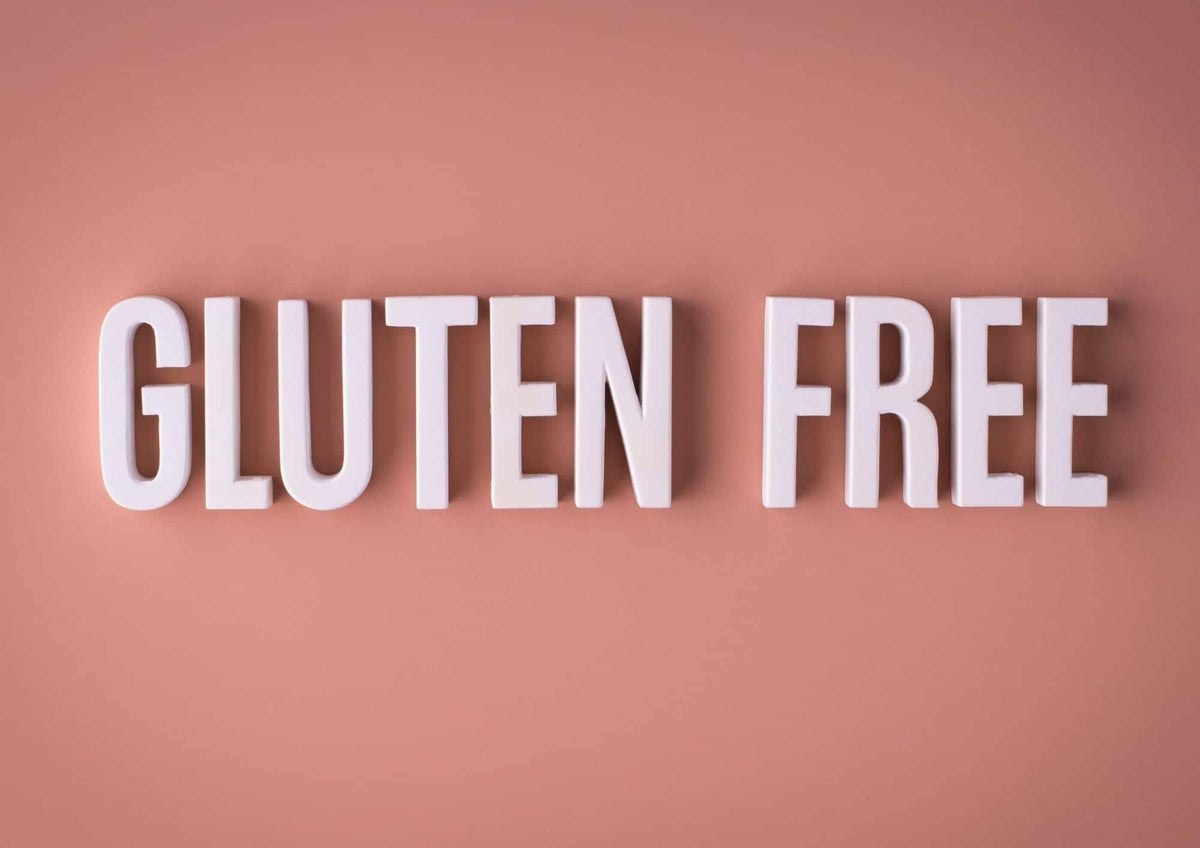 Texte gluten free en lettres blanches sur fond rose illustrant la prise en charge alimentation sans gluten