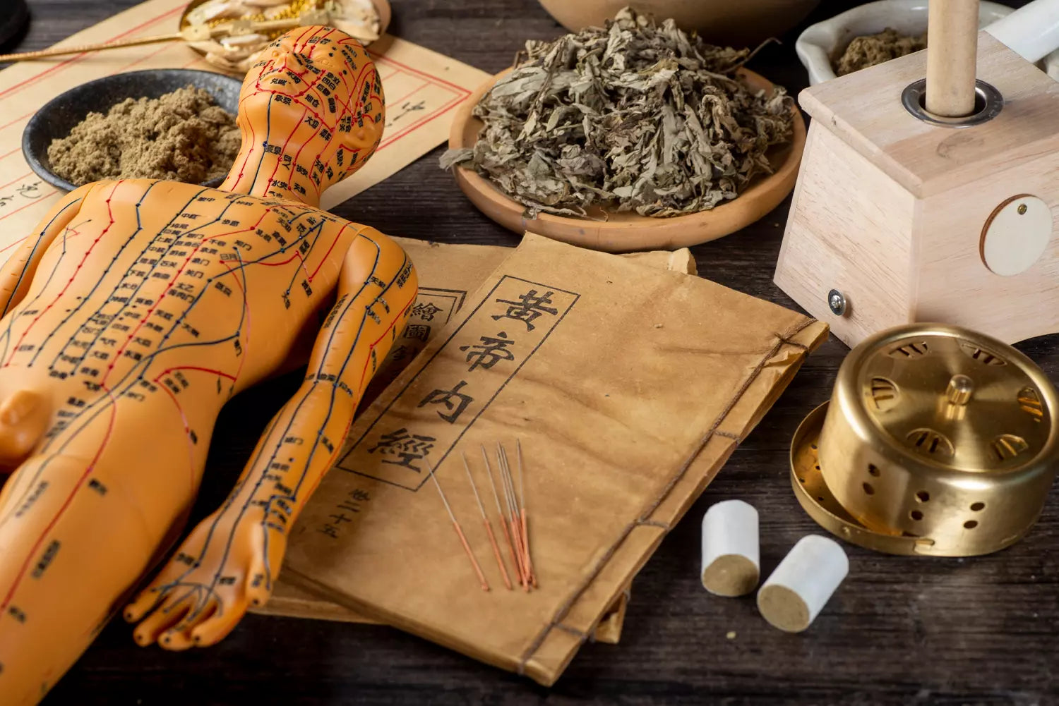 Matériel de médecine chinoise et digestion avec herbes, papiers traditionnels et figurine d'acupuncture