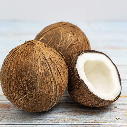 Trois noix de coco montrant leur coque extérieure et pulpe intérieure pour la digestion sensible