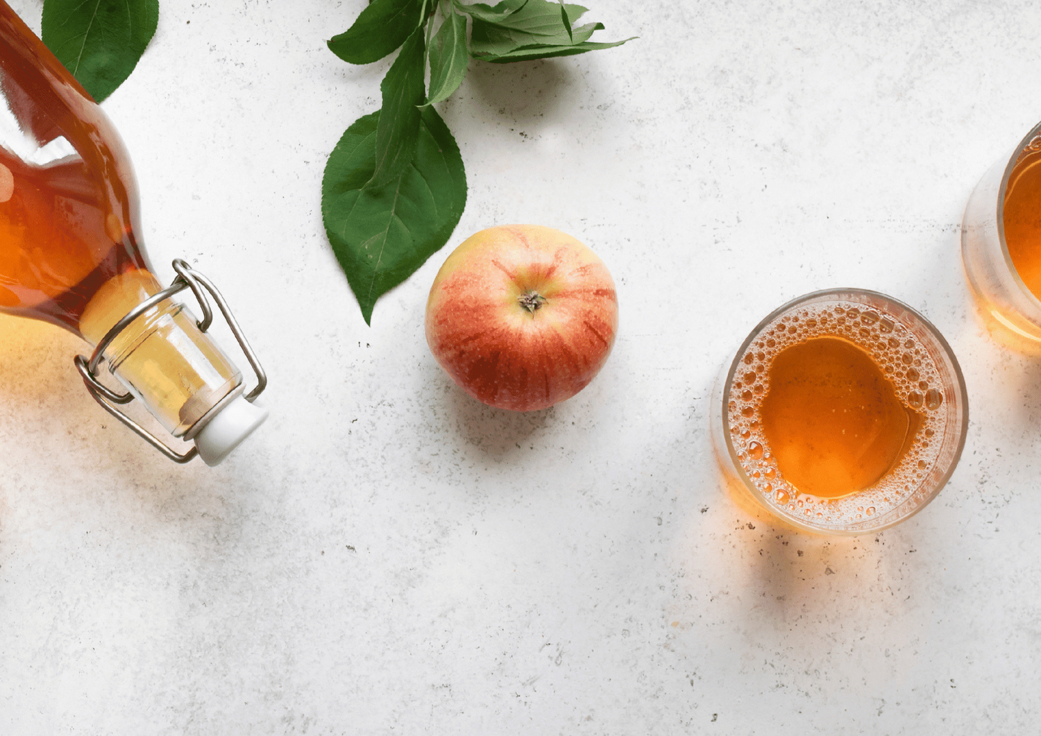 Bouteille de vinaigre de cidre, pomme fraîche et verre de liquide sur fond blanc pour bienfaits santé