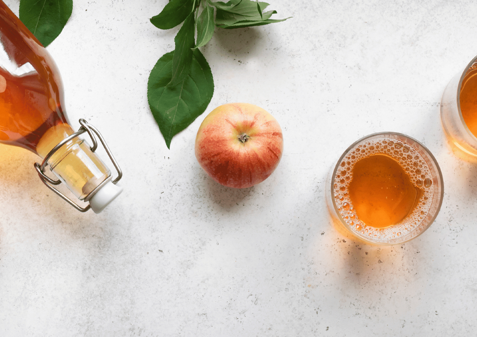 Bouteille de vinaigre de cidre, pomme fraîche et verre de liquide sur fond blanc pour bienfaits santé