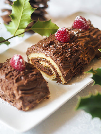 Gâteau roulé au chocolat décoré de framboises, idéal pour des recettes low fodmap
